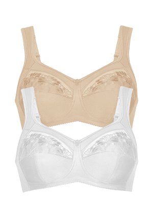 Woman standing barefoot wearing a white bra and matching high-waisted panties with floral lace panels, smiling against a plain background.