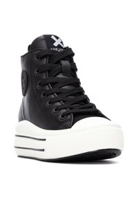 Zapatillas negras de caña alta de cuero con cordones negros y suela de goma blanca. Presentan un logo redondo y una puntera blanca en contraste.