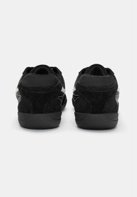 Sneakers din suede negru cu un finisaj texturat, având un design elegant, cu profil scăzut și accente subtile de gri pe părțile laterale.
