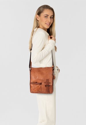 Bolso de cuero marrón tipo bandolera con superficie lisa, correa ajustable, bolsillo frontal y detalle decorativo en el herraje.