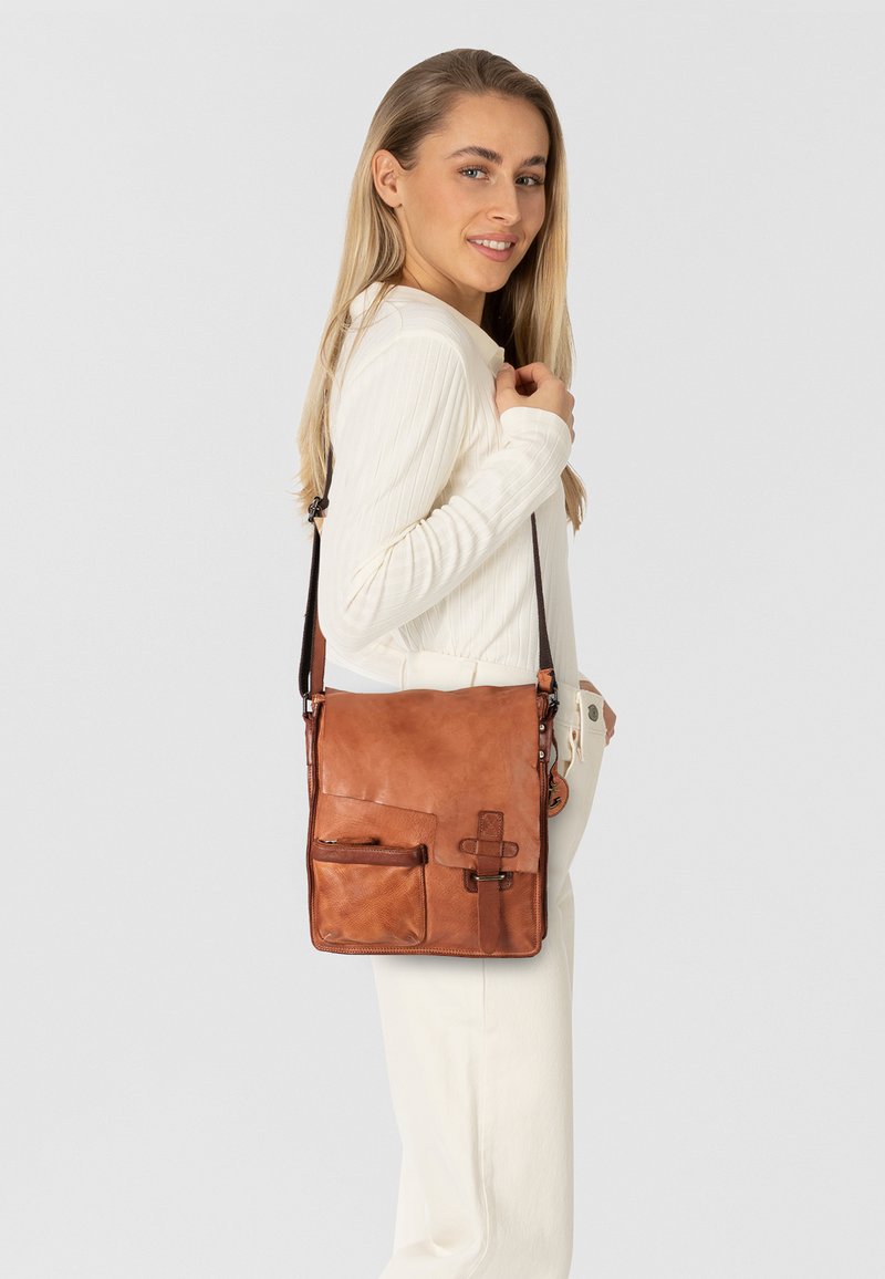 Borsa a tracolla in pelle marrone con superficie liscia, tracolla regolabile, tasca frontale e dettaglio in metallo decorativo.