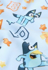 Blauwe stof met ontwerpen van cartoonfiguren, voorzien van oranje sterren en letters. De textuur is zacht en glad, met heldere kleuren en duidelijke patronen.