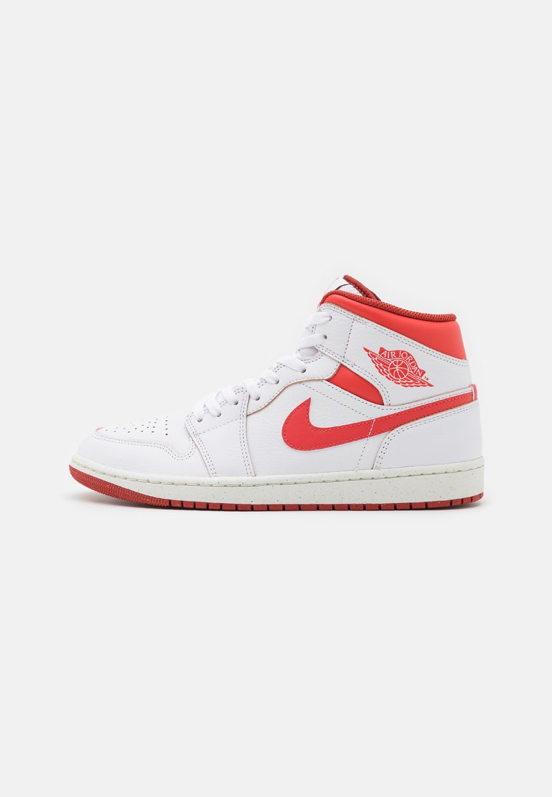 Sneaker high-top in pelle bianca con dettagli rossi, punta perforata, colletto imbottito e logo distintivo sul lato. Suola in gomma con bordatura rossa.