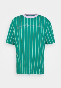 Camiseta de algodón verde con rayas verticales blancas, con un cuello lila y texto estilizado en el pecho. Mangas cortas.