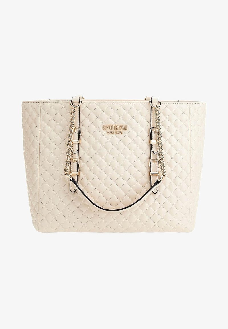 Sac fourre-tout matelassé beige Guess avec bandoulières en chaîne dorée et logo "GUESS EST 1981" au centre devant.
