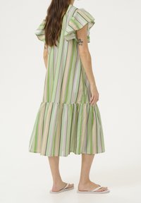 Zielona sukienka w paski z falbaniastymi rękawami, warstwowym dołem i gładkiego materiału. Paski są w jasnym zielonym, lawendowym i białym kolorze.