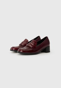 Burgundy leather loafers with a textured finish, featuring a rounded toe and a low block heel. Simple design with a raised strap accent.