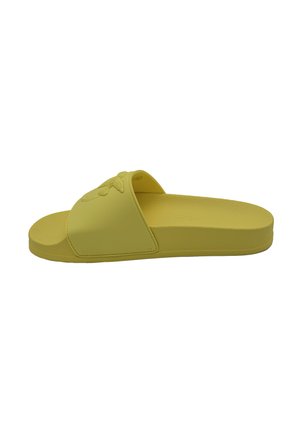 Infradito in gomma gialla con una fascia ampia caratterizzata da un design testurizzato. Suola piatta, forma minimalista, adatta all'uso quotidiano.
