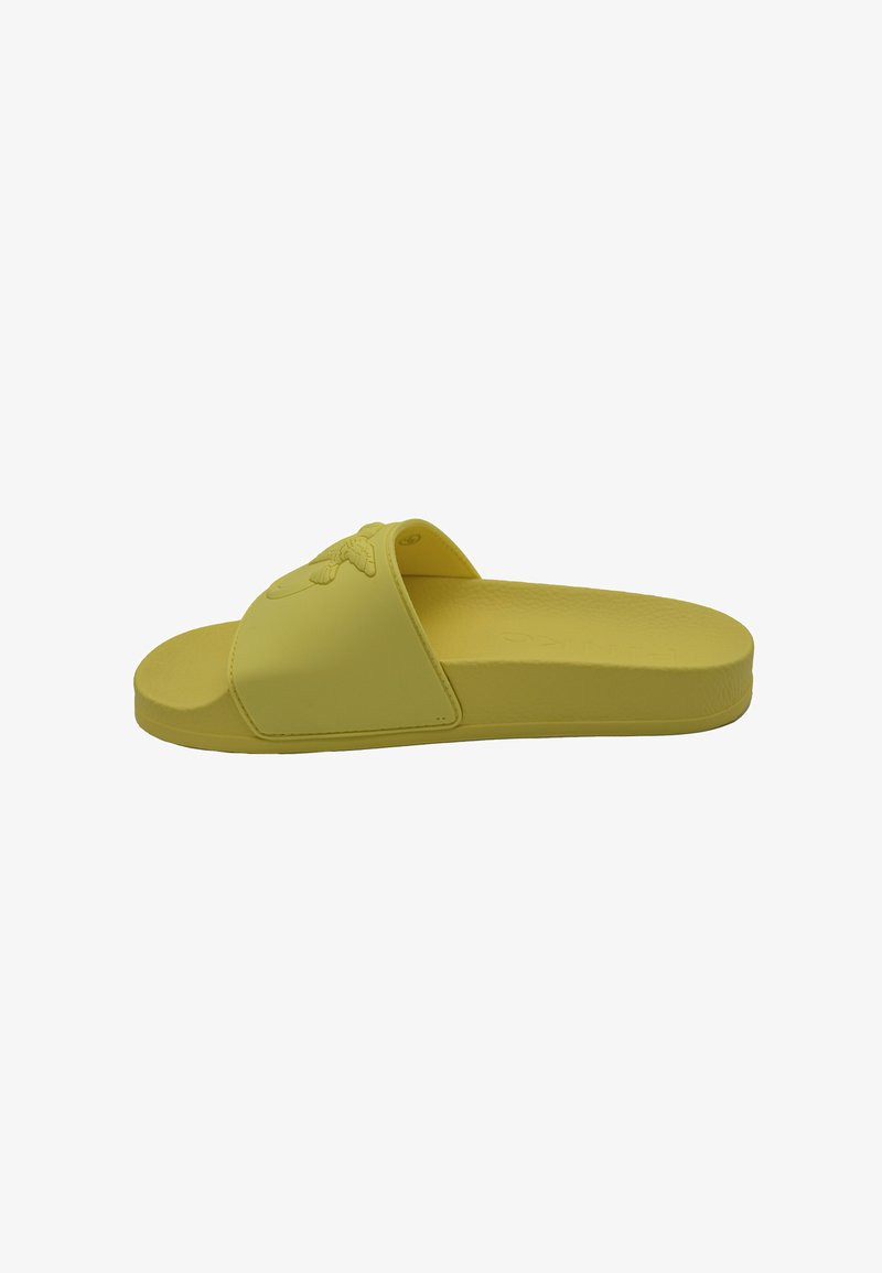 Sandale en caoutchouc jaune avec une large sangle présentant un design texturé. Semelle plate, forme minimaliste, idéale pour une tenue décontractée.