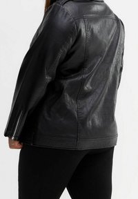 Czarna skórzana kurtka o gładkiej fakturze, z kołnierzem i zapinanymi mankietami. Charakteryzuje się dopasowanym krojem i minimalną ilością szwów.