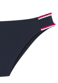Mornarsko modre bikini hlačke z širokim, teksturiranim pasom, ki ima rdeč in bel valovit trak. Gladek material in eleganten dizajn.