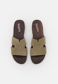 Zelené semišové šlapky s dvěma výřezovými sekcemi. Dřevěné podrážky vyznačují značku "Soficl ox" bílým textem.