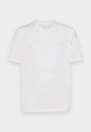 T-shirt bianco in cotone con scollo rotondo e maniche corte. Presenta testo in rilievo in un motivo a quadrato sulla parte anteriore.