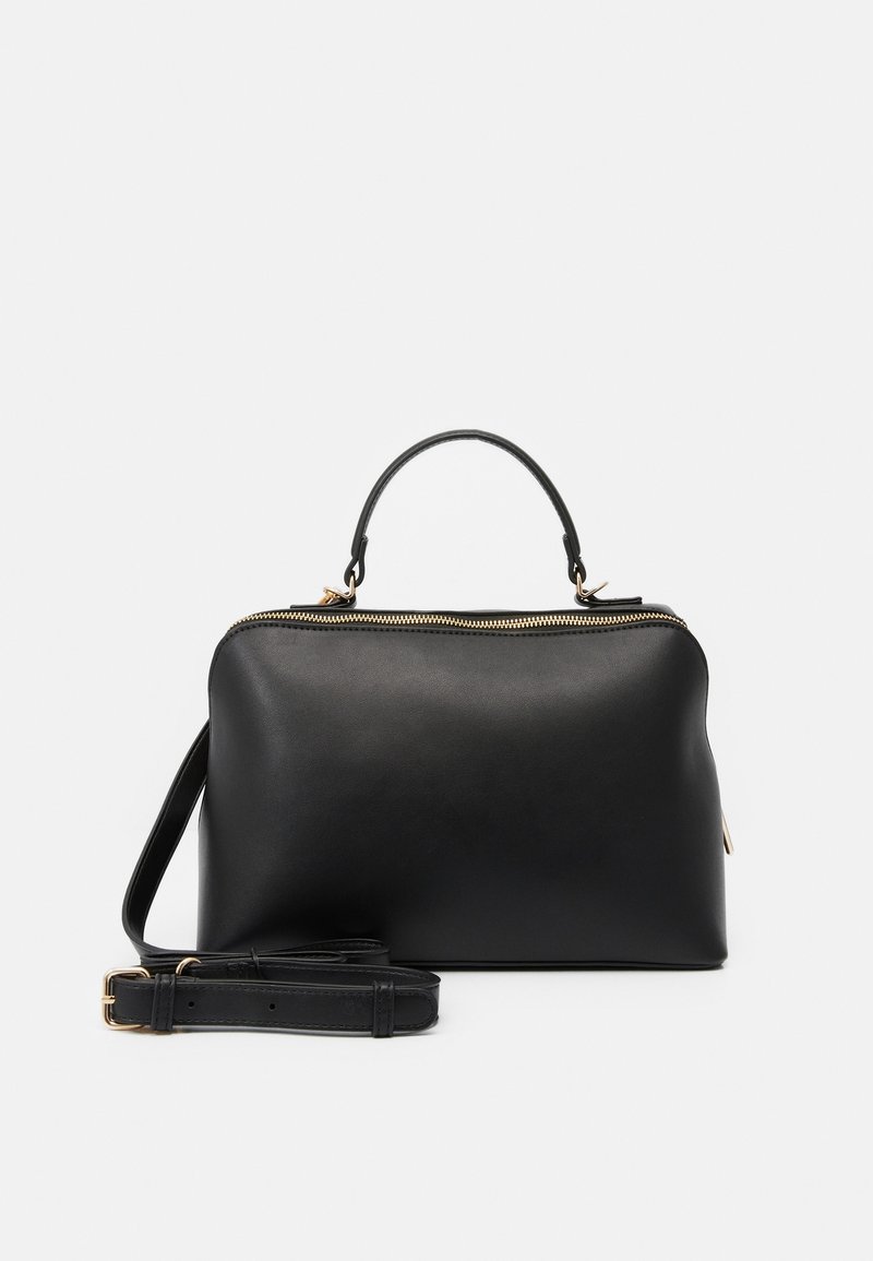 Sac à main en cuir noir avec poignée supérieure, fermeture éclair dorée et bandoulière réglable et amovible sur fond blanc.