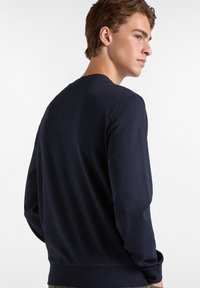 Sudadera azul marino de manga larga, cuello redondo y textura suave. Diseño simple, sin patrones ni acentos visibles.