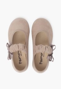Zapatos Mary Jane de ante beige con punta redonda, correa elástica fruncida y un pequeño lazo decorativo en el lateral. Forro interior suave.