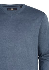 V-hals trui van een zachte, gestructureerde blauwe stof. Voorzien van een label met de merknaam en maatlabel aan de binnenkant van de halslijn.