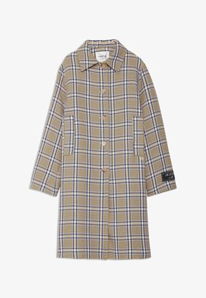 Long manteau beige à carreaux avec des lignes bleues et blanches, fermeture à boutons, deux poches avant et un patch noir sur la manche gauche.