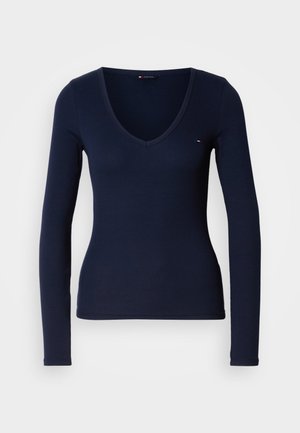 Námornícke tričko s dlhým rukávom a rebrovanou textúrou, s výstrihom do V. Obsahuje malý logový akcent na hrudi.
