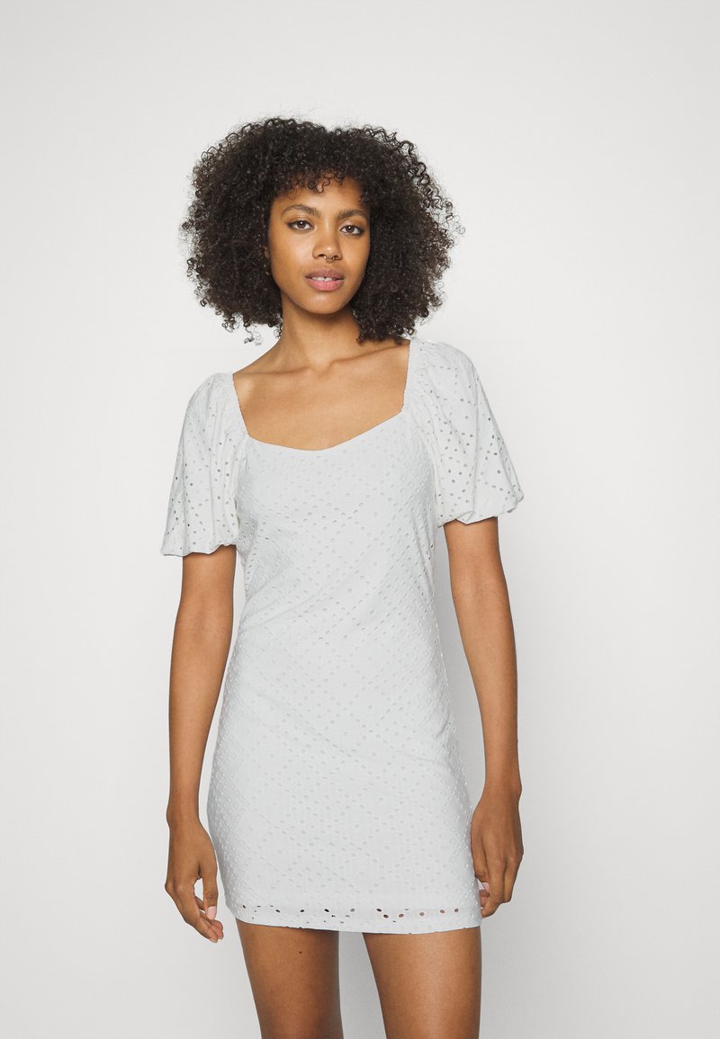 Vestido cinza claro com mangas curtas bufantes, decote quadrado, tecido texturizado com padrões de pontos e forma ajustada.