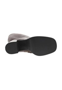 Bottines en cuir marron avec un bout arrondi et une tige texturée. Semelle extérieure en caoutchouc noir avec un talon plat, présentant une finition lisse.