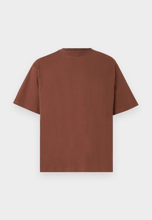 Enkel brun t-skjorte med korte ermer og rund hals, lagt flatt mot en lys grå bakgrunn.