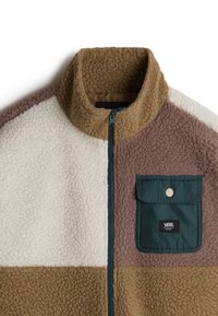 Sherpa fleecejakke med høj krave, der har farveblokke i brun, creme og beige. Inklusiv en grøn lommen med trykknaplukning.