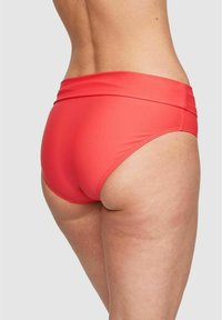 Röda simbyxor med hög midja, tillverkade av ett slätt material. Designen har en måttlig skärning med minimala sömmar.