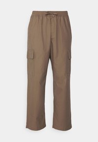 Hnědé cargo kalhoty s elastickým pasem a šňůrkou, s postranními klopovými kapsami a rovnými nohavicemi na bílém pozadí.