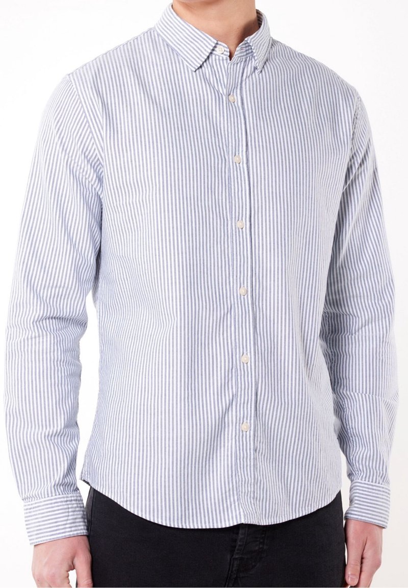 Koszula na guziki z pionowym, niebiesko-białym paskowanym wzorem, długimi rękawami, spiczastym kołnierzykiem i zaokrąglonym dołem. Wykonana z bawełny.