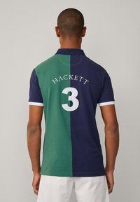 Poloko s vertikálními pruhy v zelené a námořnické modré barvě. Má bílý límec, text "HACKETT" a velké bílé "3" na zádech. Materiál: bavlna.