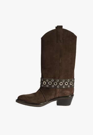 Botte de cowboy en suède marron avec un bout pointu, un talon court et une bande en cuir noir ornée d'œillets argentés autour de la cheville.