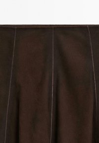 Donkerbruine suède rok met zichtbare verticale stiksels en een zachte textuur.