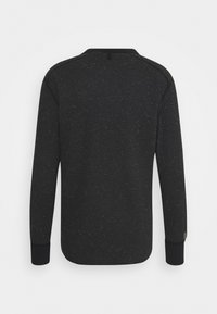 Black long-sleeve sweater with speckled texture, round neck, and contrasting cuffs. Features a logo accent on the left sleeve.