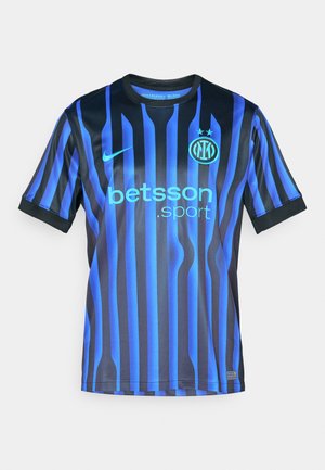 Maillot de football bleu et noir à rayures avec des manches courtes. Il présente un col rond, le logo Nike et le texte "betsson.sport" en bleu clair.