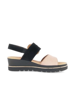 Sleehak sandaal met zwarte enkelriem, beige voorriem, gevoerde zool en een getextureerde zwarte buitenzool op een witte achtergrond.