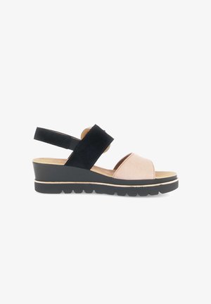 Sleehak sandaal met zwarte enkelriem, beige voorriem, gevoerde zool en een getextureerde zwarte buitenzool op een witte achtergrond.