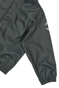 Chaqueta de nailon negra y suave con cierre a presión, puños elásticos y detalle de logo reflectante en la manga. Diseño de corte holgado.