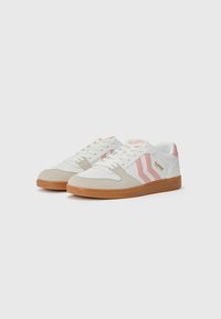 Sneakers atletici bianchi e rosa con dettagli in suede beige, dotati di tre strisce diagonali e una suola in gomma testurizzata.
