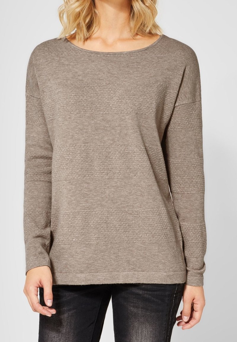 Pull léger marron clair à manches longues avec un motif texturé, col rond et coupe décontractée. Matière douce et design simple.