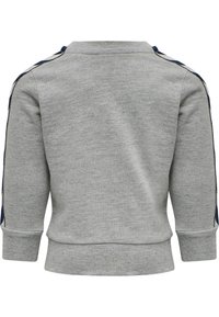 Grå sweatshirt med ribbad ärm- och nederkant, med marinblå och vita ränder på axlarna. Mjuk fleece-materiel.