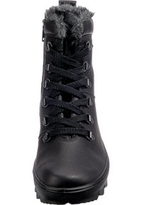 Botín negro con cordones, con parte superior de cuero sintético y ribete de pelo sintético. Presenta un upper texturizado, una suela robusta y ojales de metal para los cordones.