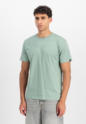 Hellgrünes T-Shirt mit kurzen Ärmeln aus weicher Baumwolle. Verfügt über einen Rundhalsausschnitt und einen kleinen Logodruck auf der Vorderseite. Lässige Passform.