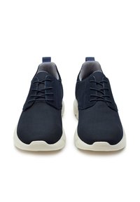 Sneakers in rete blu con lacci piatti, colletto imbottito, fodera grigia e suola in gomma bianca. Punta arrotondata e design minimalista.