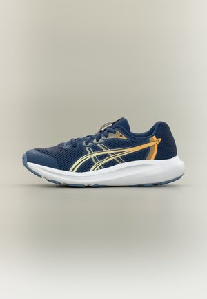 Chaussure de course bleu marine avec semelle blanche et bandes de logo jaunes, tige en mesh et fermeture à lacets, vue de côté sur fond beige.