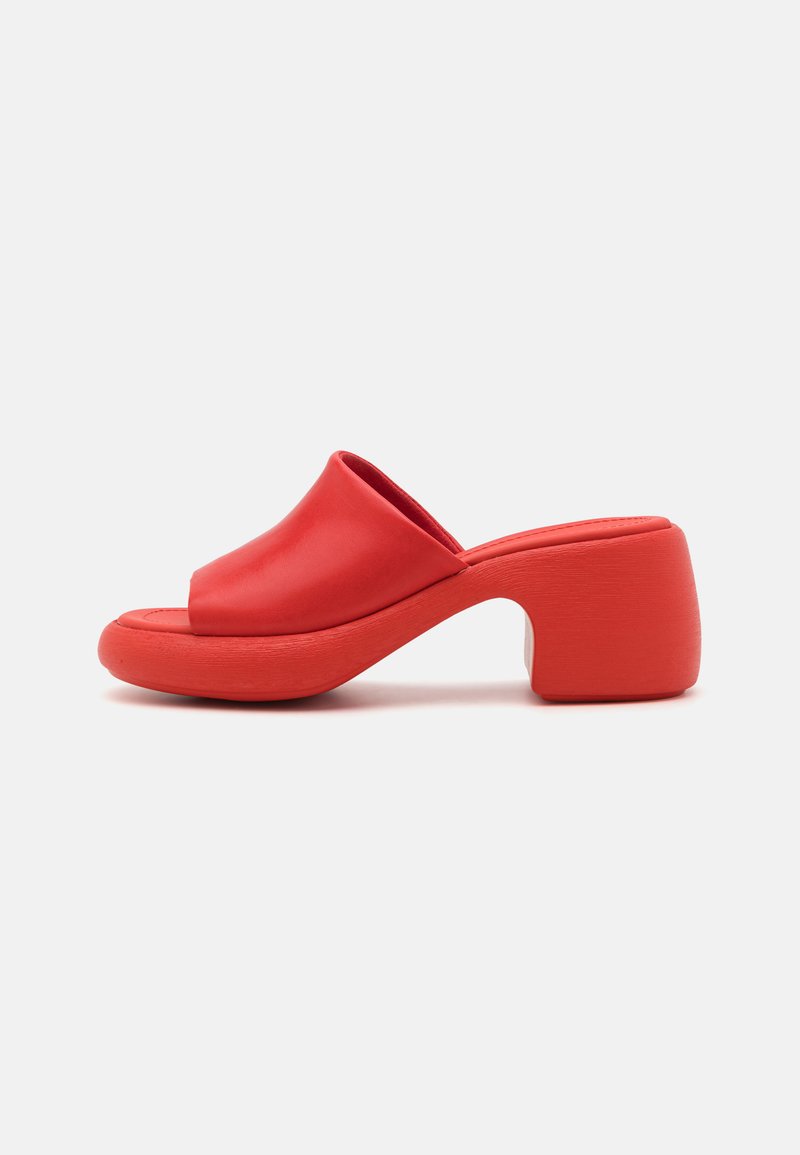 Sandalha aberta vermelha com biqueira arredondada e um salto bloco espesso e esculpido. Textura suave e design minimalista.