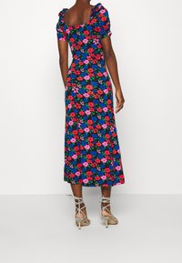 Květinové šaty s kulatým výstřihem, krátkými nabíranými rukávy a sukní střední délky. Mají černé pozadí s červenými, modrými a růžovými květy.