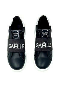 Sneakers sintetici neri con suola bianca, una larga fascia nera con l'etichetta "GAËLLE" e dettagli argentati sul tallone.