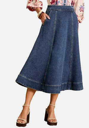 Denim A-lijn rok met hoge taille, zijzakken, contrasterende stiksels en een uitlopende zoom. Gemaakt in combinatie met beige plateau sandalen.