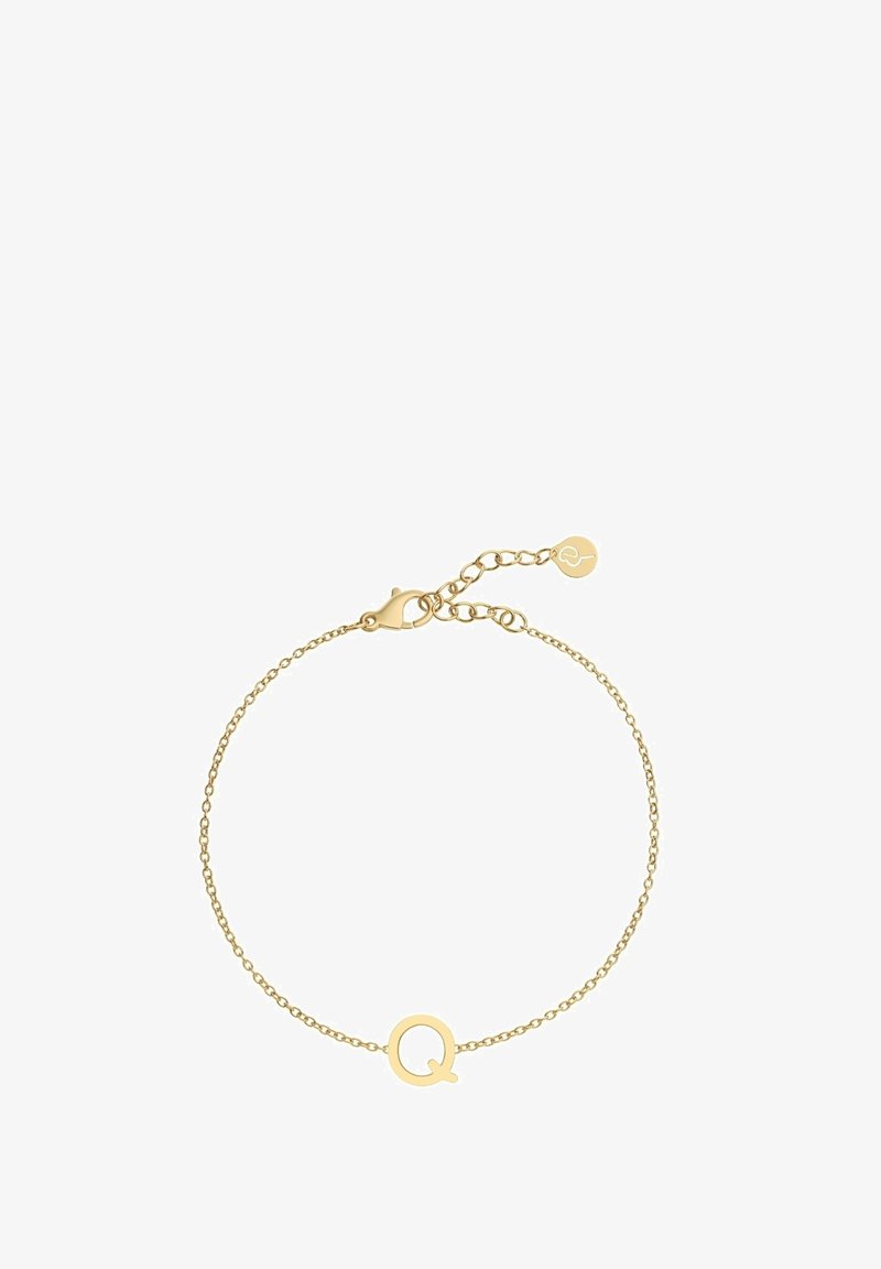 Kulta ketjuhihna, jossa on minimalistinen muotoilu ja pyöreä "Q" -riipus. Säädettävä solki, johon on kiinnitetty pieni tagi.